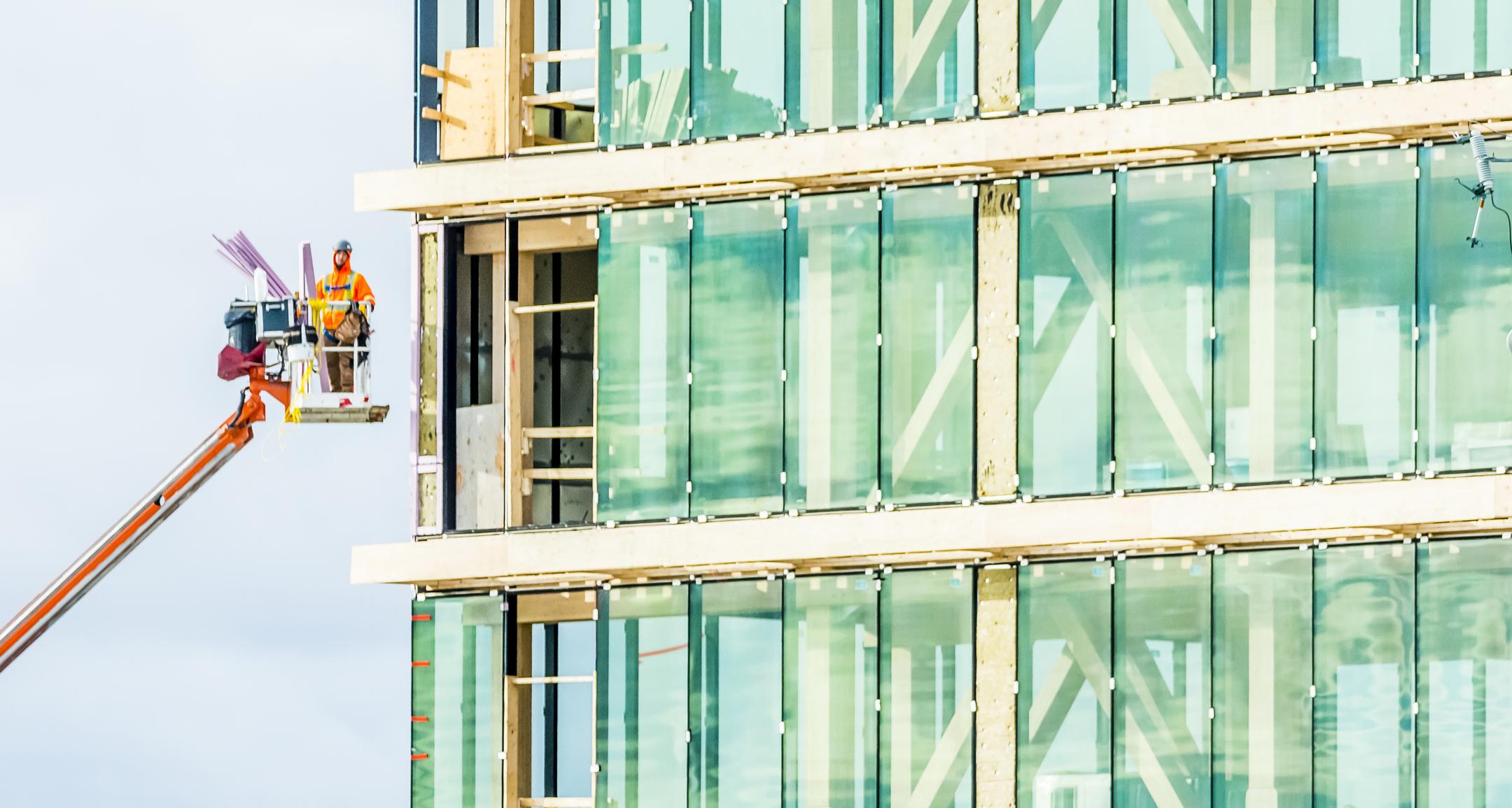 man on scaffolding next to building