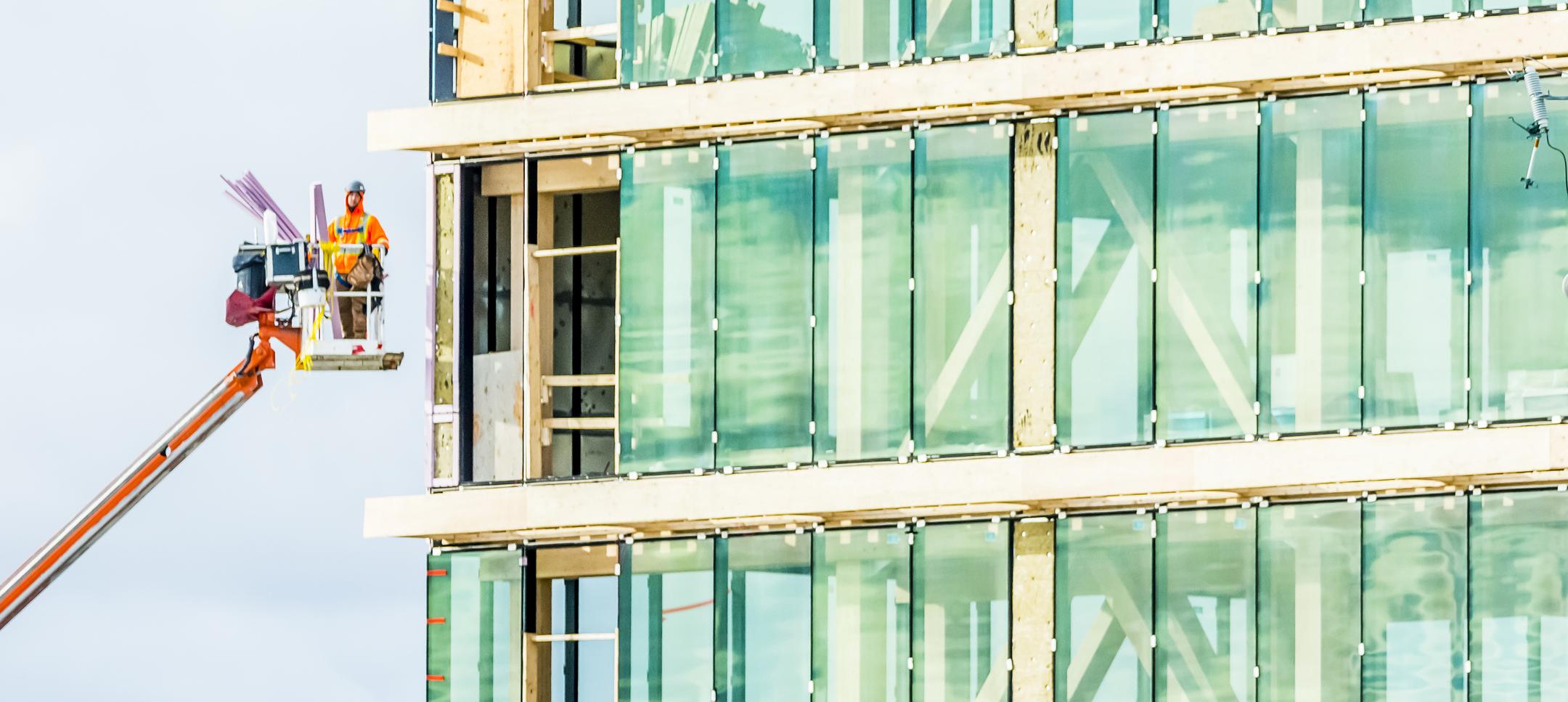 man on scaffolding next to building