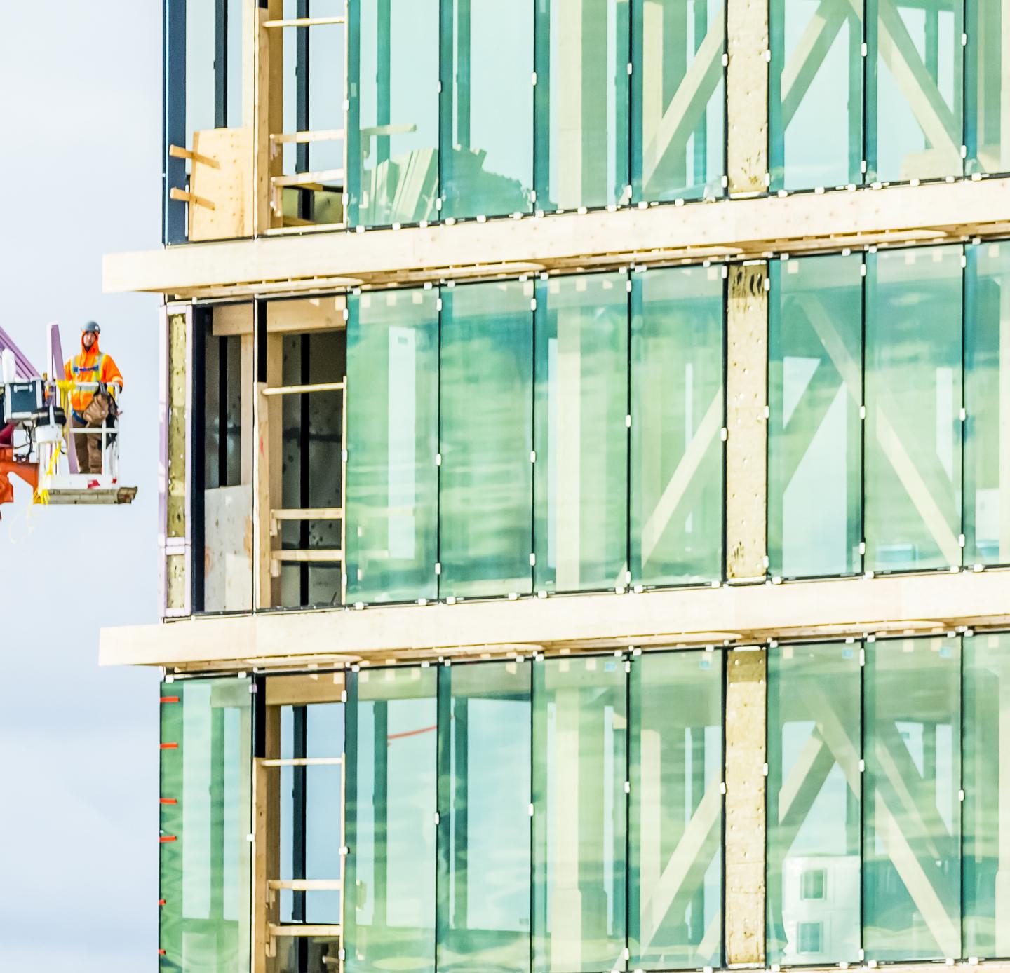 man on scaffolding next to building